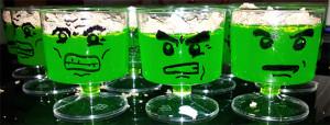 picture of green jelly in plastic shot glasses with hulk face drawn on.